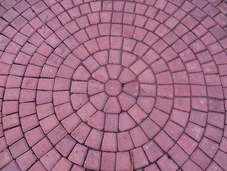 A spiral pattern of red brinks on a sidewalk.        の写真素材