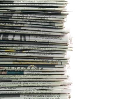 Old newspapers stacked from the top to bottom of the frame isolated on white.