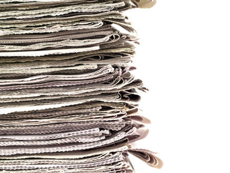 Old newspapers stacked from the top to bottom of the frame isolated on white.の写真素材