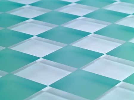 A glass checkerboard with clear and frosted squares with mirrored effect.の写真素材