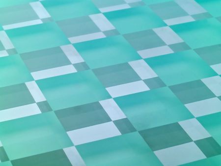 A glass checkerboard with clear and frosted squares with mirrored effect.の写真素材