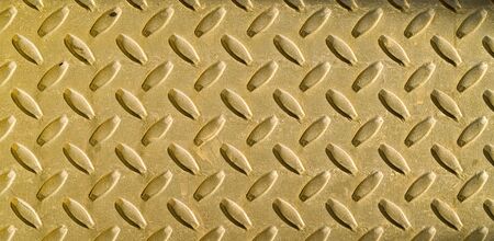 Diamond gold toned metal background texture illuminated by sunlightの写真素材