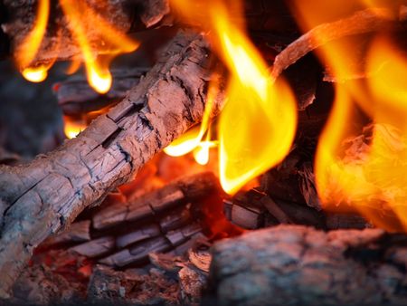 Flames in a fire pit with glowing embersの写真素材