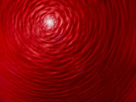 An abstract of a vortex and lens flare in a red color toneの写真素材