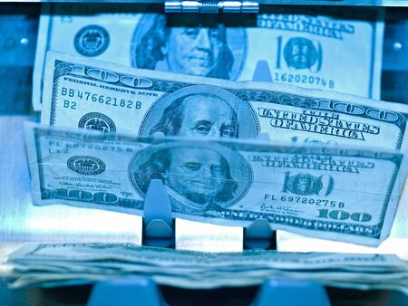 An electronic money counter processing US $100 billsの写真素材