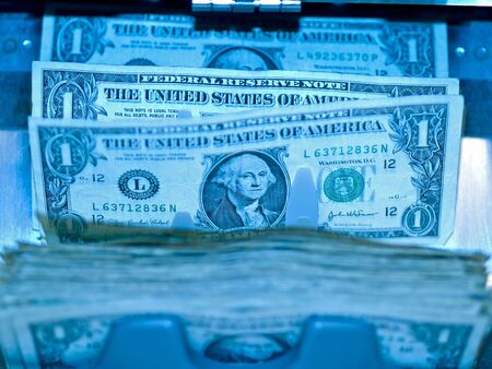 An electronic money counter processing US $1 billsの写真素材