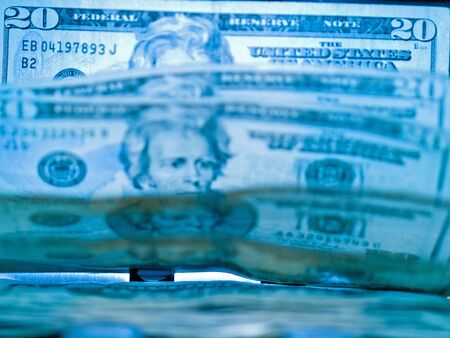 An electronic money counter processing US $20 billsの写真素材