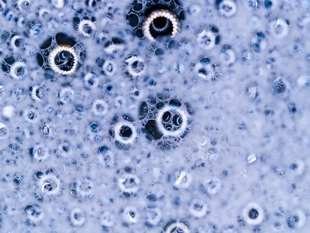 Soap bubbles with reflections macro with blue colored backgroundの写真素材