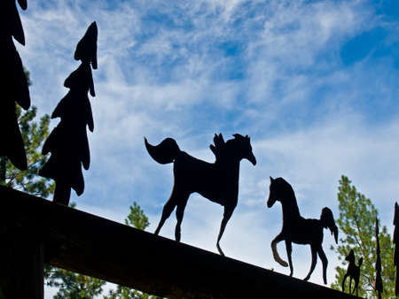 Metal Horse Sculpture Silhouetted Against a Wispy Blue Skyの写真素材