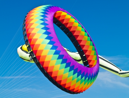 Colorful Ring Kite Flying in a Bright Blue Sky at the Long Beach Kite Festivalのeditorial素材
