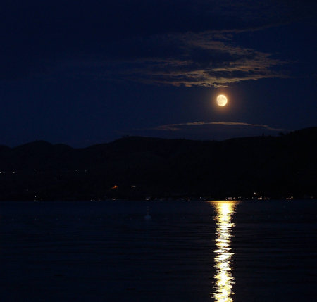 Moonlight Reflecting on a Lake in the Night Skyの写真素材