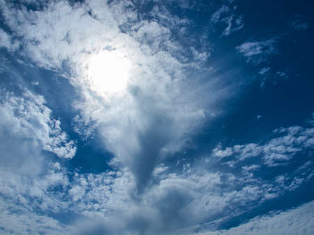 A Bright Sun Behind Some White Clouds