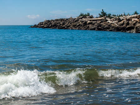 Gentle Beach Waves with a Rock Jetty