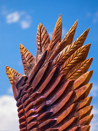 Closeup of an Eagle Wing Chainsaw Sculpture Showing Carved and Burned Woodの写真素材