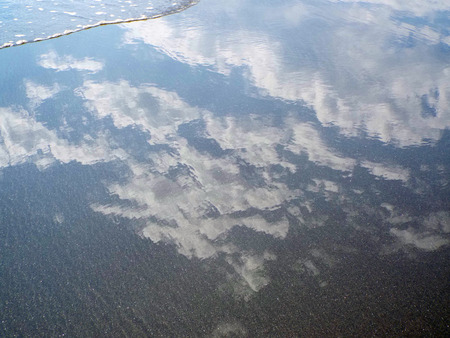 Sky and Clouds Reflections in the Water at the Shore