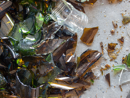 Broken Glass Bottle Pieces on a Cement Floorの写真素材