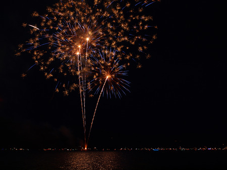 Long Exposure of Fireworks Reflecting on Calm Rippling Water
