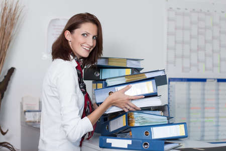 Young businesswoman stacks files on a table in the officeの写真素材