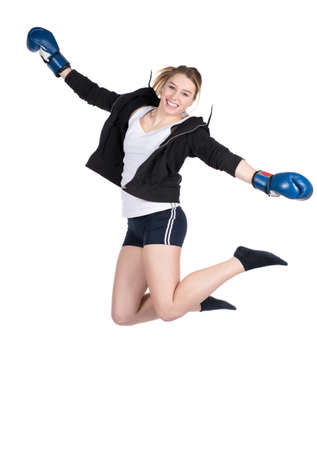 Cut out image of a young smiling female boxer wearing a hoody and blue boxing gloves, who is jumpingの写真素材