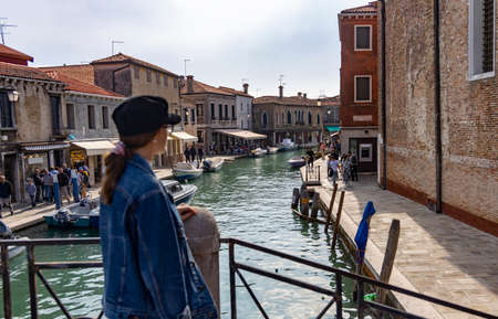 girl standing on a bridge in venice italy, canals in venice with gondolaのeditorial素材