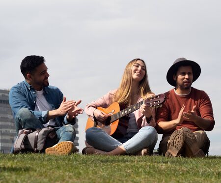 YOUNG PEOPLE PLAY GUITAR IN THE PARKの写真素材