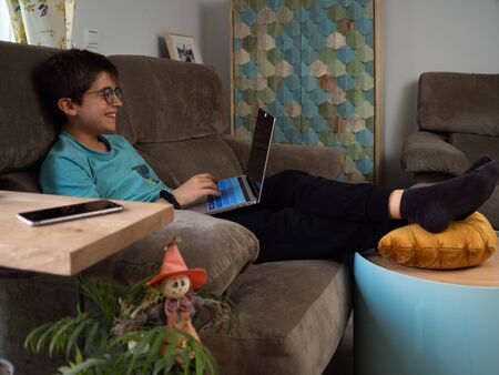 A boy using laptop at the living roomの写真素材