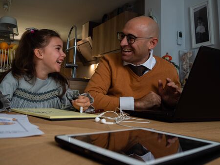 Father and daughter stay at home and workingの写真素材