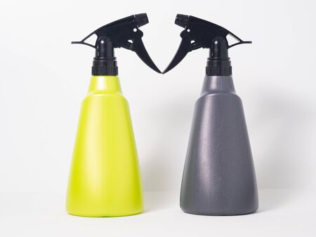 Spray cans, one green and one grey, on a white backgroundの写真素材