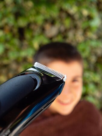 FATHER CUTTING HIS SON'S HAIR AT HOME, DURING CONFINEMENT