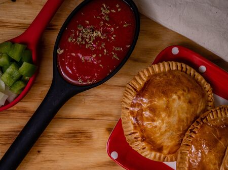 HOMEMADE PASTIES OF TUNA, TOMATO AND PEPPERS ON A WOODの写真素材