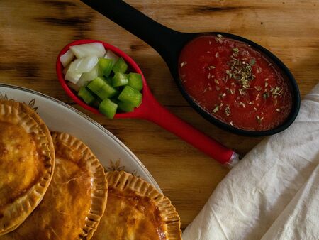 HOMEMADE PASTIES OF TUNA, TOMATO AND PEPPERS ON A WOODの写真素材