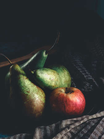 GREEN PEARS AND FRESH RED APPLES ON A DARK BACKGROUND. FRESH FRUITS. VERTICAL PHOTO.の写真素材
