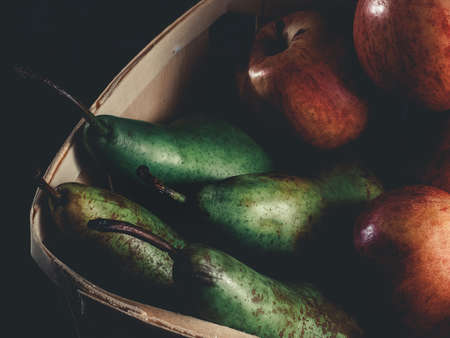 GREEN PEARS AND FRESH RED APPLES ON A DARK BACKGROUNDの写真素材