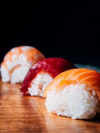 close-up of three pieces of sushi, nigiri, dark backgroundの写真素材