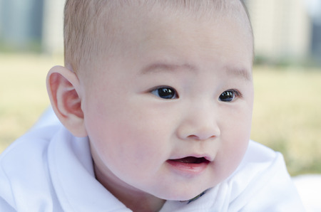 Infant lying on the grassの写真素材