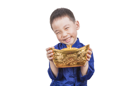 Happy boy holding golden ingot for the new year mean get rich and luck.の写真素材