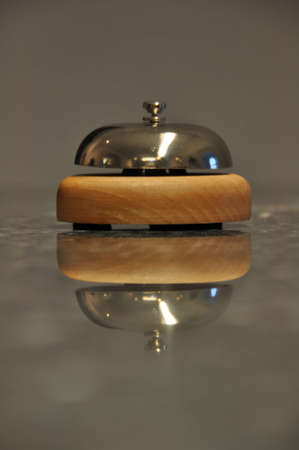 Detail shot of a service bell located on a hotel reception desk with great reflection on marble...