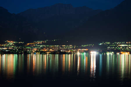 View on Mandello De Lario from the opposing shore at Lake Como at nightの写真素材