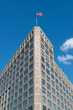 Impressive Manhatten building and America flag as seen from upward