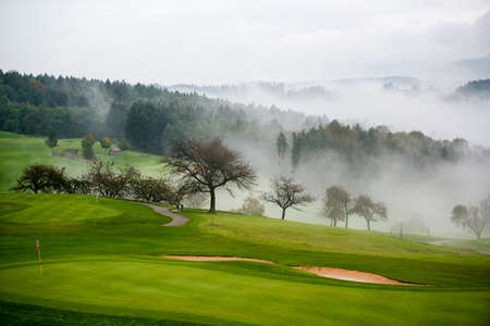 Autumn on the golf course in the mist at sunriseの写真素材