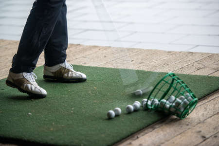 Man hits range balls at the practice area of a golf courseの写真素材