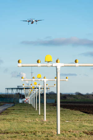 Airport landing lights with airplane approaching runway lighting and radarの写真素材