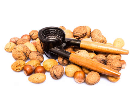 mixed nuts and nutcracker with shadows on white background
