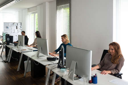 Young team working at desks in stylish officeの写真素材