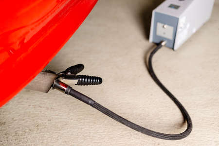 A diagnostic sensor is applied to the ehaust of a red car, measuring the composition and substances...