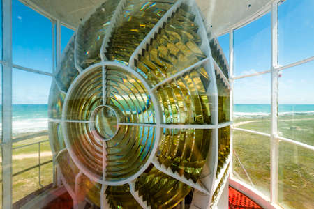 An up close view of the light of the Cape Agulhas lighthouse (southernmost point of Africa) with a view of the ocean in the background.の写真素材