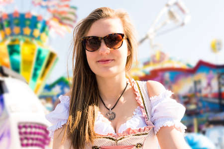Attractive young woman at German funfair Oktoberfest with traditional dirndl dressの写真素材