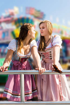 Attractive young women at German funfair Oktoberfest with traditional dirndl dressesの写真素材