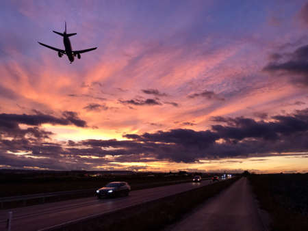 A plane is approaching Stuttgart AIrport during a dramatic sunset