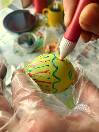 Woman painting an easter egg for holiday, hello spring conceptのeditorial素材